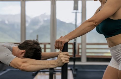A couple working out together at an indoor gym with mountain views.