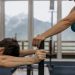 A couple working out together at an indoor gym with mountain views.