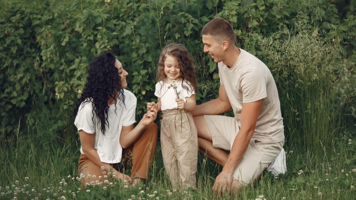 A joyful family enjoying time together in a lush green field.