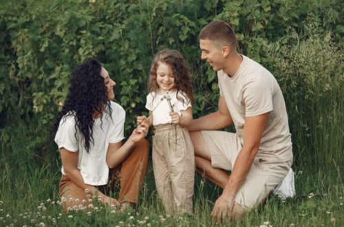 A joyful family enjoying time together in a lush green field.