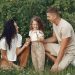 A joyful family enjoying time together in a lush green field.